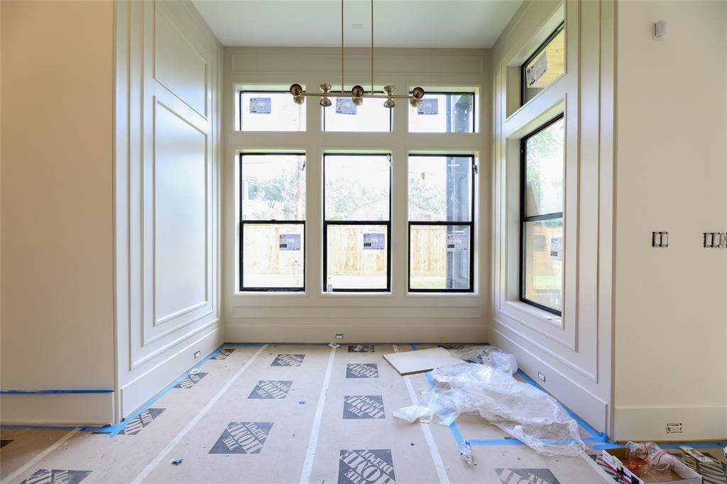 Breakfast Area is adorned with fabulous wall panel detail, large windows/transoms & high-end light fixture.