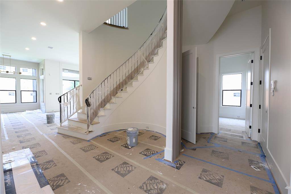 Wood floors throughout 1st floor w/ elegant winding staircase & rotunda. 1st Floor Guest Suite & under staircase storage closet behind staircase.
