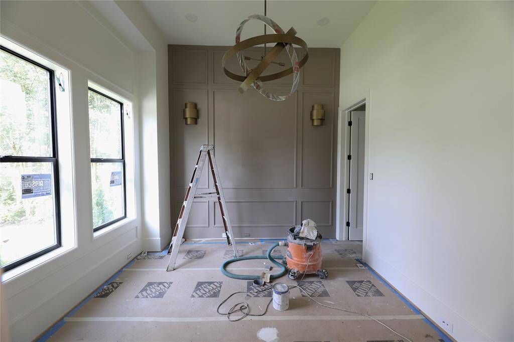 1st Floor Study offers wall panel detail, sconces & large windows to let in natural light.