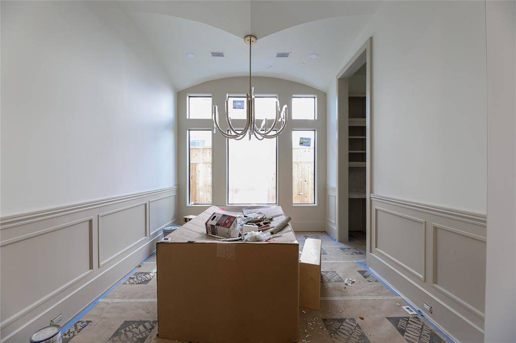 Formal Dining room offers exquisite wainscoting, large windows/transoms, high-end chandelier & ceiling detail.