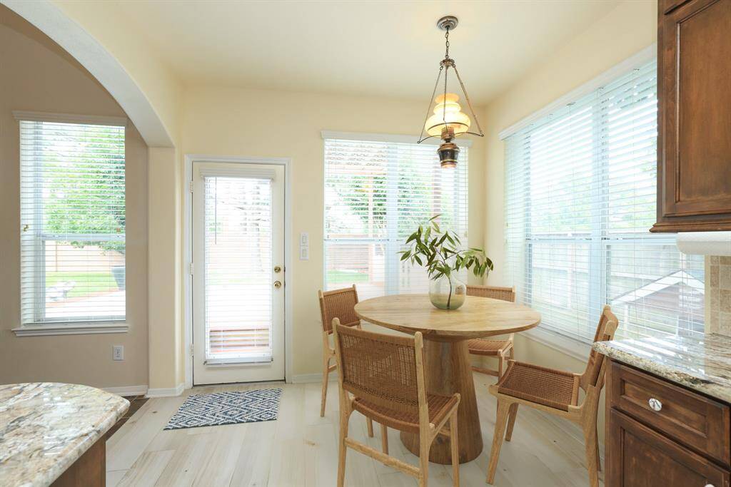 Cozy breakfast nook with Antique chandelier.Tumbled marble backsplash and copper style accents above cooktop. Granite countertops. Wood look ceeramic flooring.