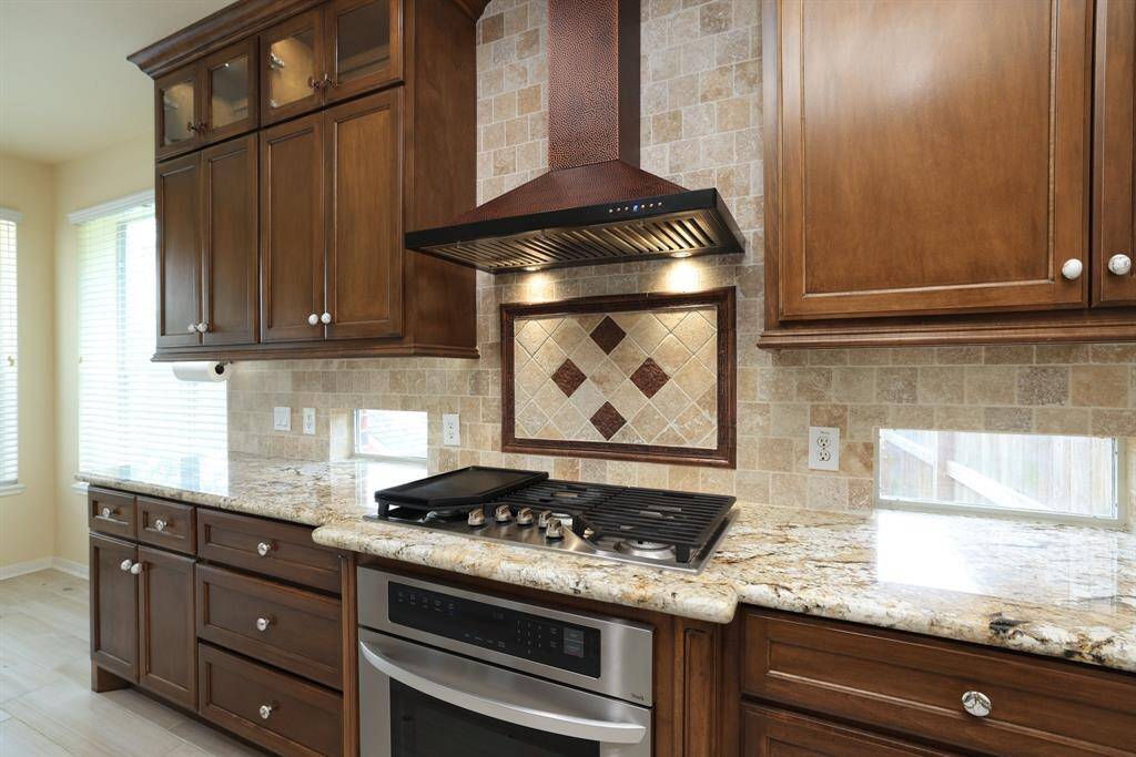 GE Profile 5 burner gas cooktop with griddle feature.Copper range hood w/lights and exhaust fan to the outside.