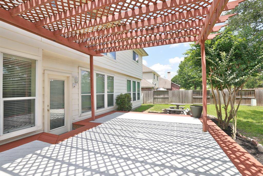 Concrete decorative dining table with mosaic tile inlays remains with property. Stone walkway to sideyard.