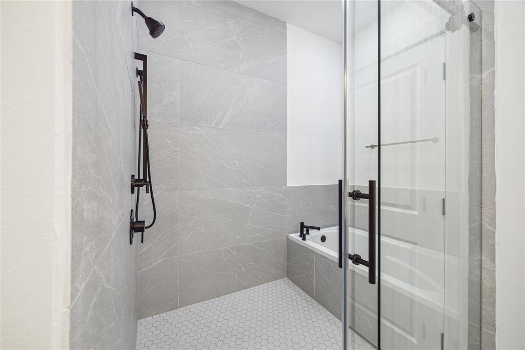 The large glass shower with striking modern tile, a soaking tub and rain showerhead.