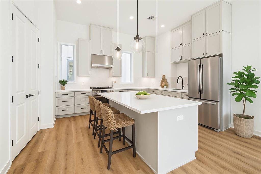 The kitchen in this beautiful Jamye plan has tall upper cabinets, quartz countertops, stunning, faux stacked stone backsplash and gorgeous hardware.