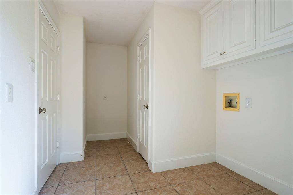 First floor laundry area with plenty of space and light with a extra storage room and a second refrigerator space. Gas or electric Dryer hookup. Storage cabinets above washer and dryer provide more storage options.