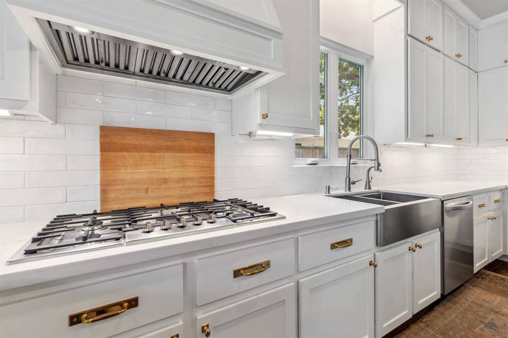 Thoughtful lighting design — including recessed fixtures, pendants and under-cabinet lighting — provides ideal illumination throughout the spacious kitchen.
