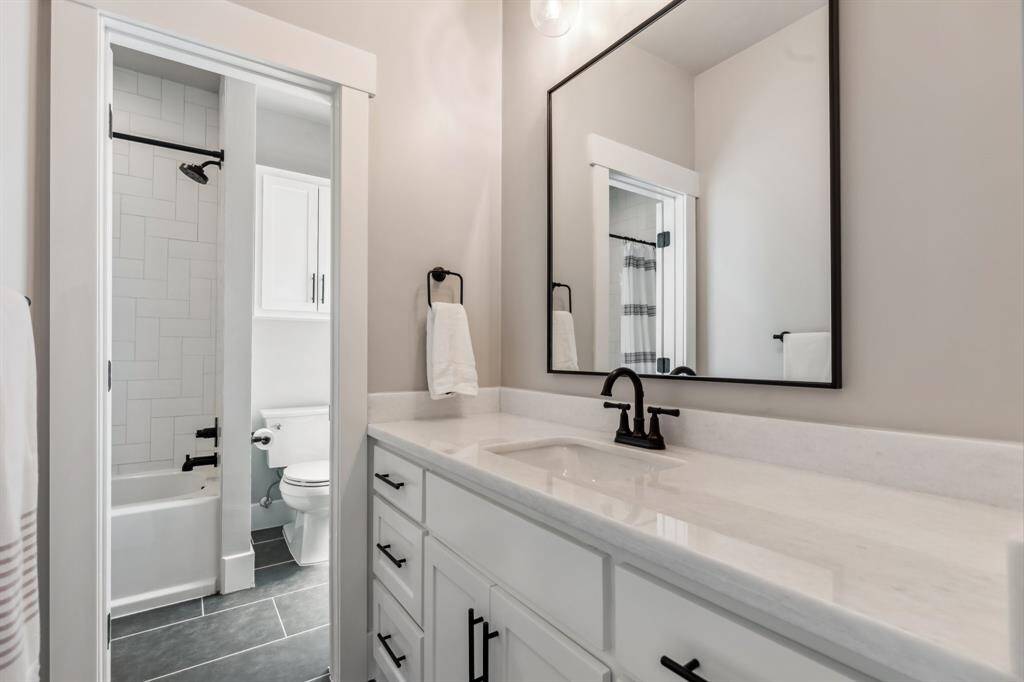Morning routines are easy thanks to the remodeled Jack-and-Jill bathroom’s two separate vanity areas, plus a shared tub/shower and commode.