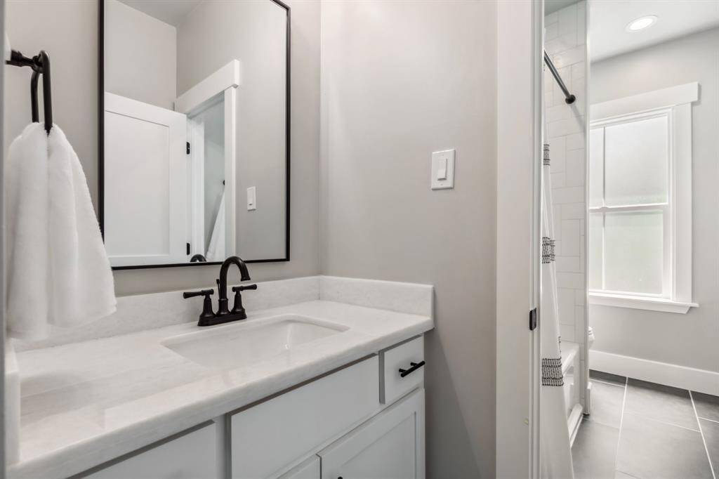 Throughout the remodeled Jack-and-Jill bathroom, you’ll find marble countertops, chic matte black hardware, large-format floor tile and herringbone tile in the shower.