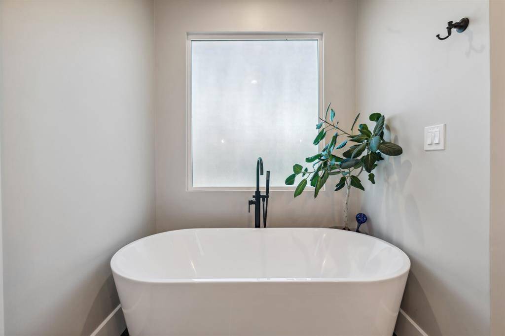 Soak away your troubles in the freestanding soaking tub equipped with a hand sprayer.