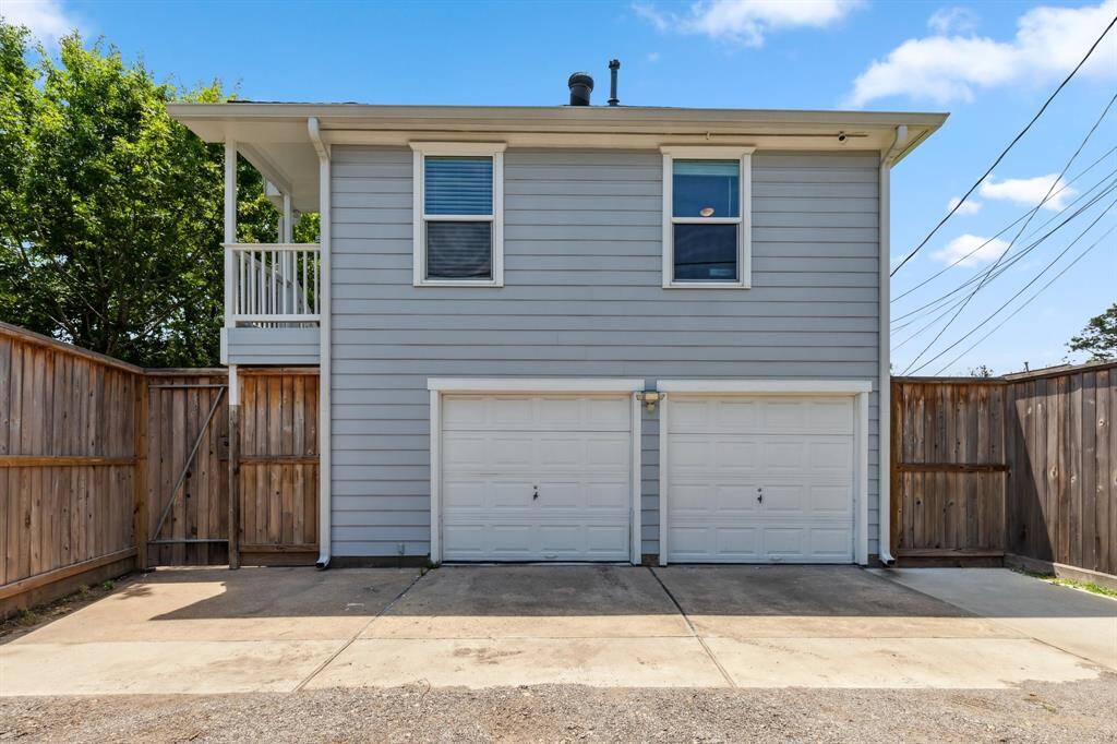 Off the alley, a wide driveway and two-car garage featuring repainted doors with openers, epoxy floors, built-in storage, a sink and tool bench provides plenty of off-street parking and hobby space.