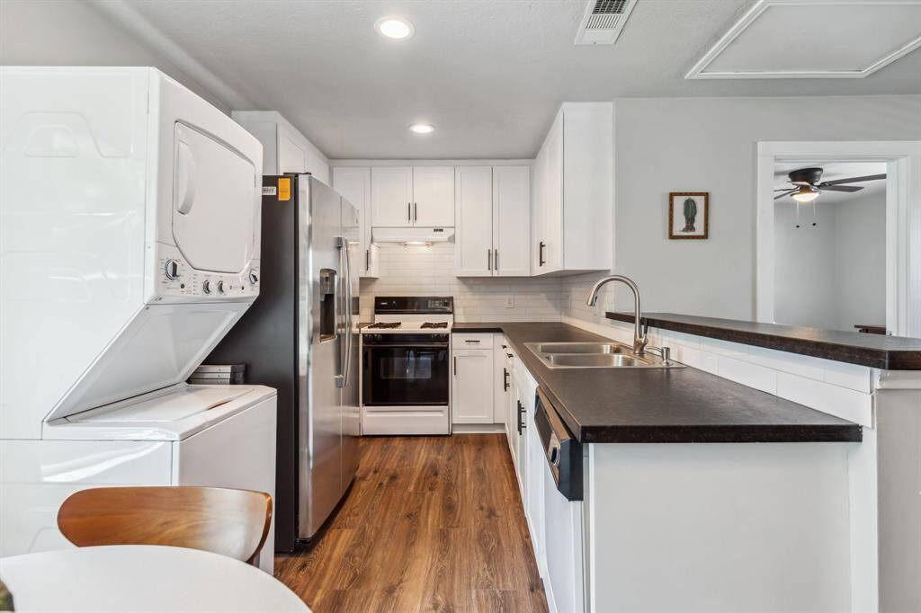 Optimized for space-saving convenience, the open kitchen offers rows of cabinetry, new countertops and an in-unit washer-dryer.