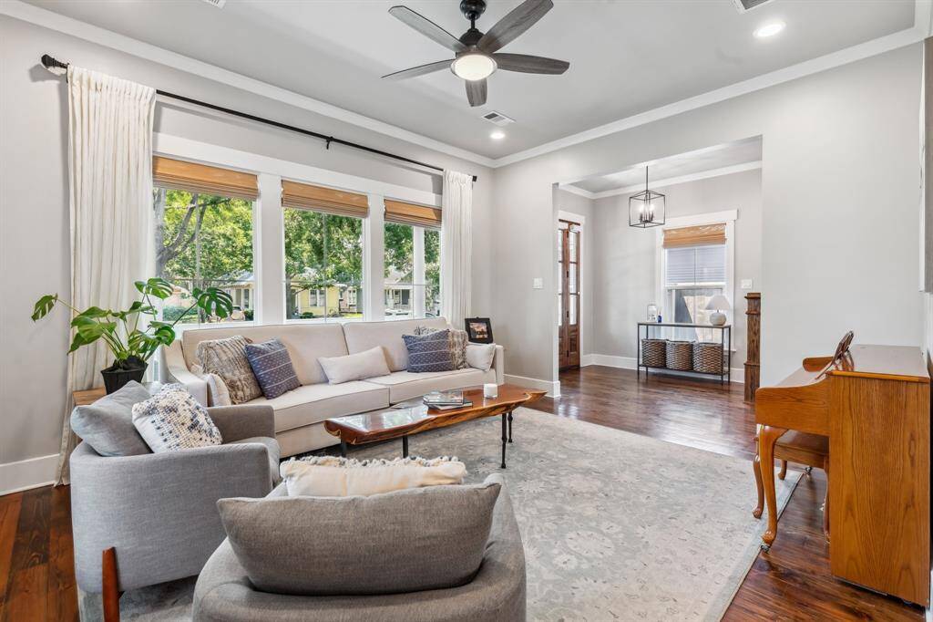 Stretch out in the formal living room, where a ceiling fan provides year-round comfort. Windows with custom shades run throughout the home.