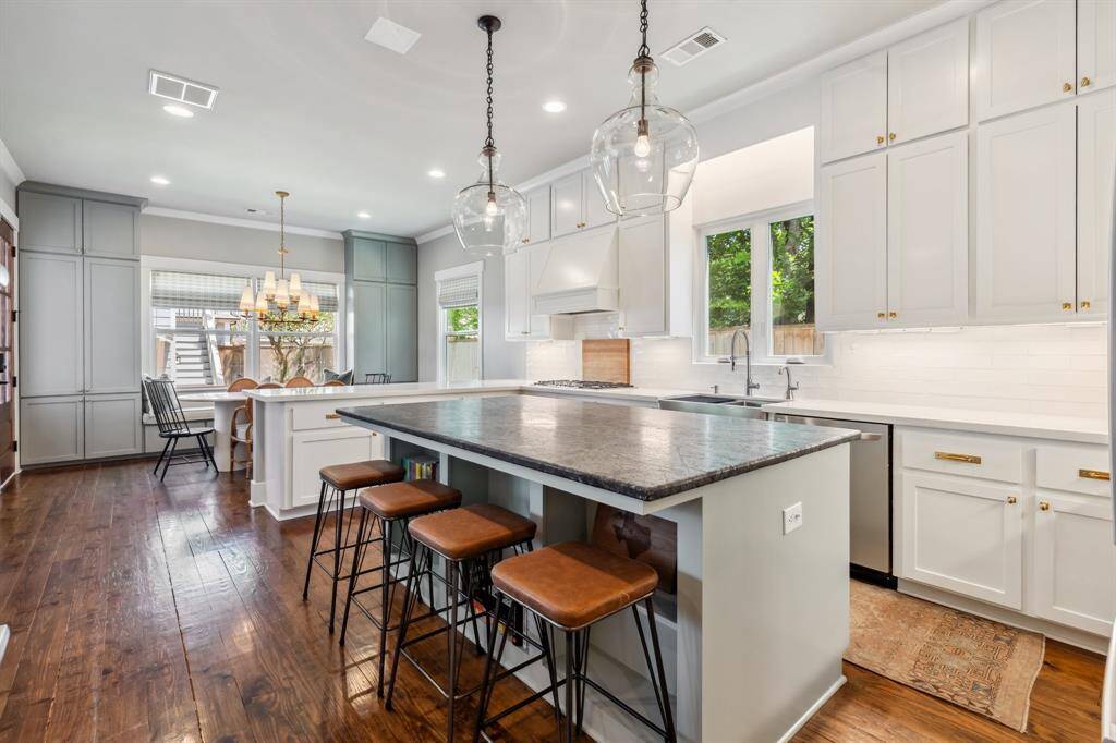 Completely remodeled in 2020, the gourmet kitchen impresses with floor-to-ceiling cabinetry featuring new gold hardware, quartz and soapstone countertops, subway tile backsplashes and a stainless steel farm sink.