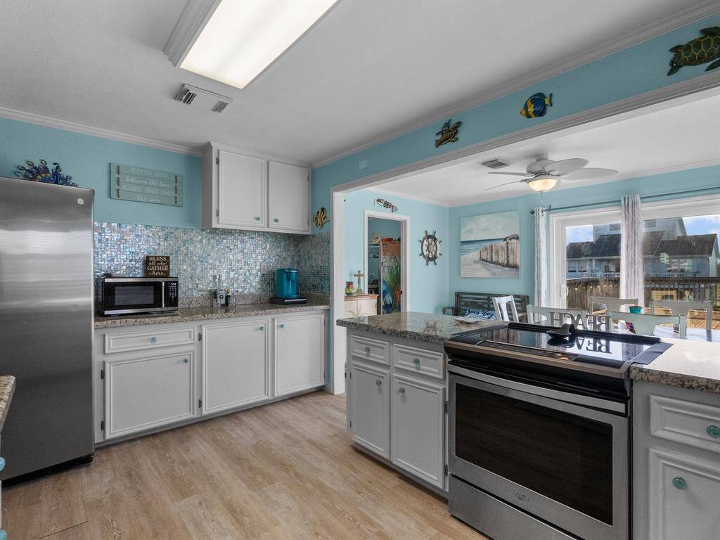 A good view of extra cabinetry and counter space, a peek into the laundry room, dining room and vast deck outside.