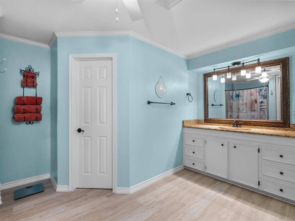 Primary bathroom has double closets, LVP flooring, custom mirror and beautiful touches.