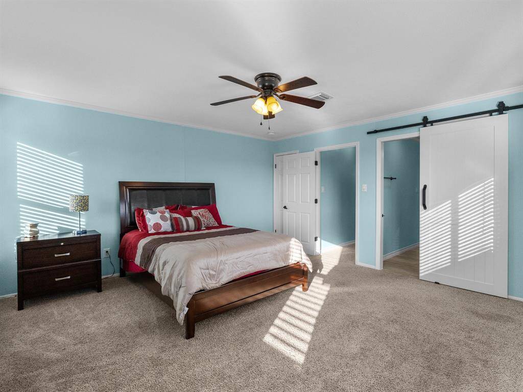 Primary bedroom upstairs has barn door leading to en suite bathroom.