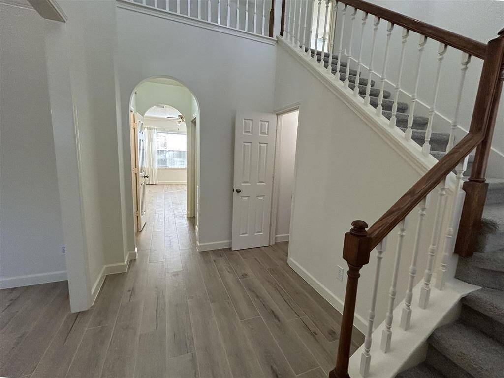 The two story entryway features wood-look tile and a large storage closet underneath the stairs.