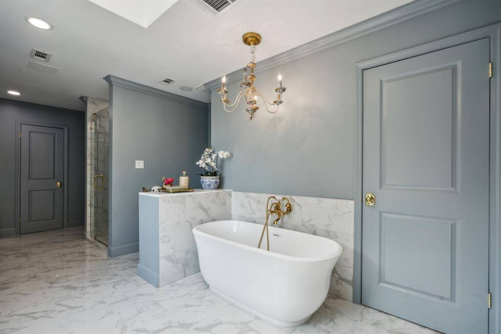 Freestanding tub with gold fixtures and designer color choices.