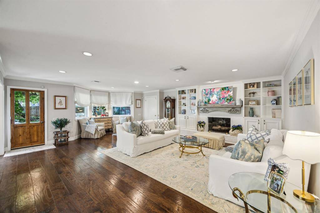 Open den features hardwood floors, recessed lights, gas log fireplace, and built-ins.