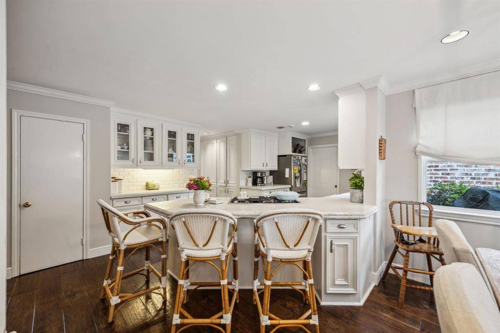 Kitchen features a breakfast bar, abundant countertop space, and tons of custom pantry storage.