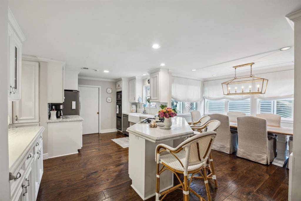 Kitchen is complete with gorgeous finishes including marble countertops, gas stove top, wine fridge, and double oven.