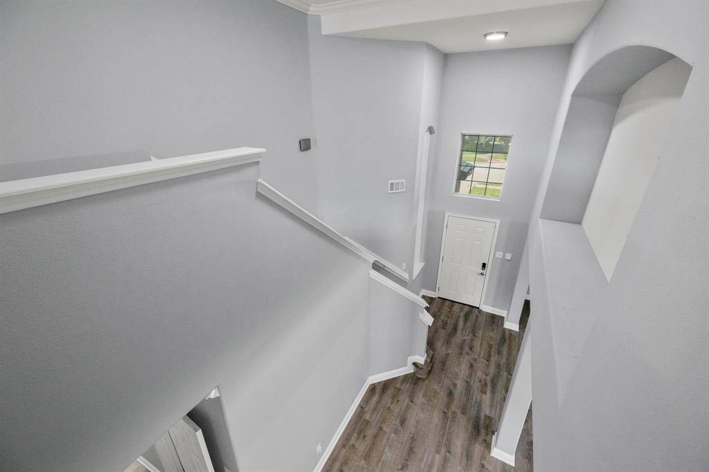A striking overlook from the upper level provides a captivating view of the first floor below, drawing attention to the home's soaring ceilings and open-concept design.