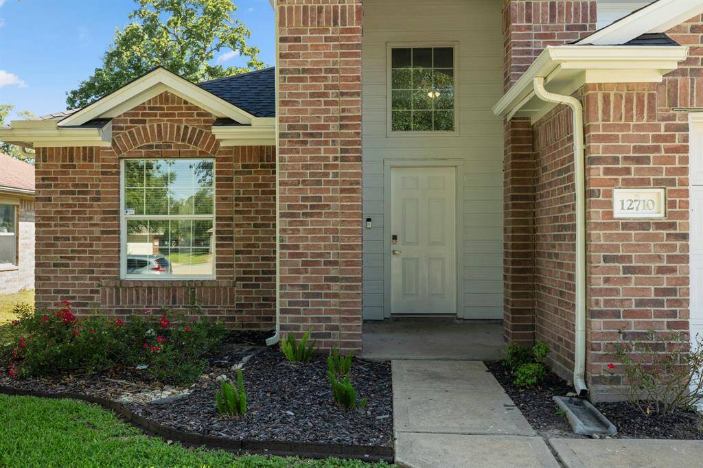 A covered porch provides a cozy, sheltered space ideal for seasonal décor or a quiet moment outdoors.The professionally landscaped flower beds feature blooming rose bushes and fresh mulch, adding a pop of color and curb appeal.