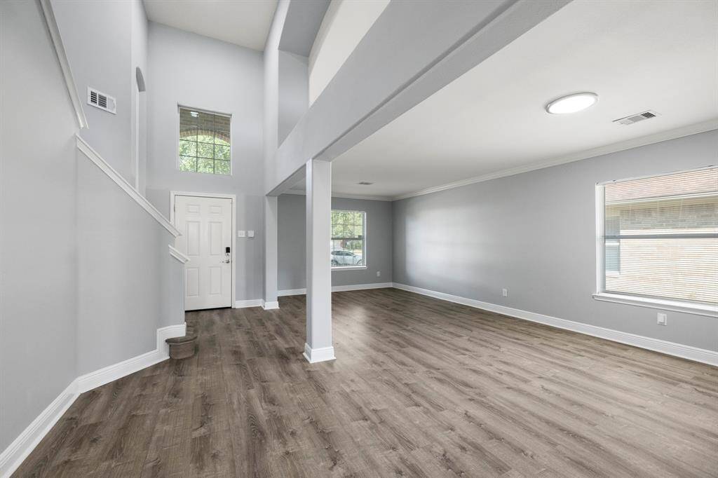 Bright entry with soaring ceilings, open layout, modern flooring, and abundant natural light throughout.