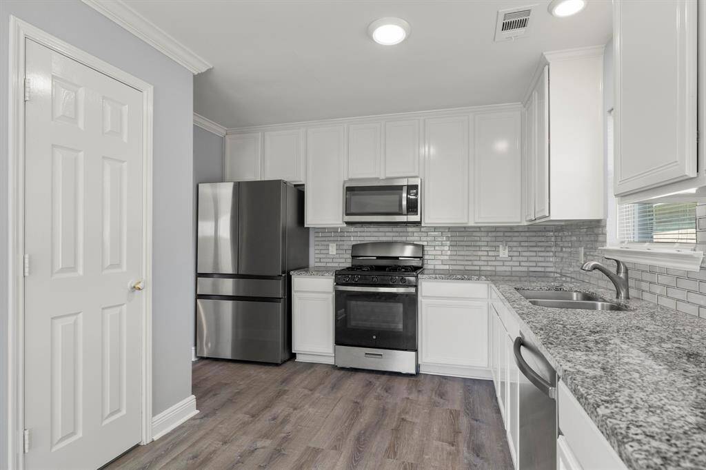The chef's kitchen boasts stainless steel appliances, a gas range with four burners, TONS of cabinets for ample storage.