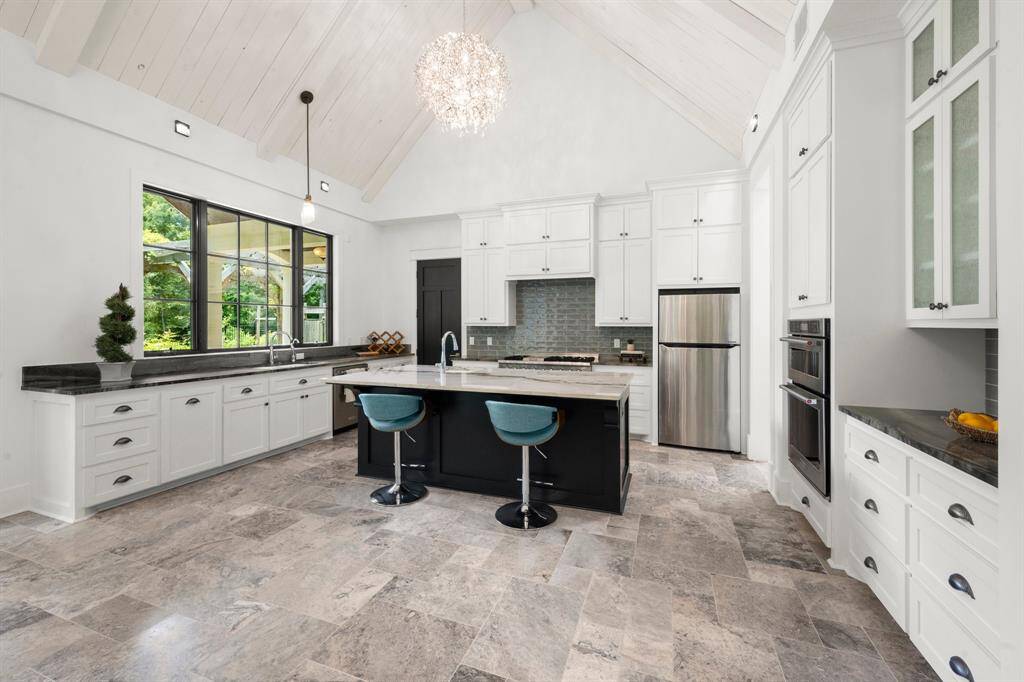 Timeless white hardwood upper cabinets and all soft-close drawers below counter storage, including conveniet drawers to easily acces and store spices.