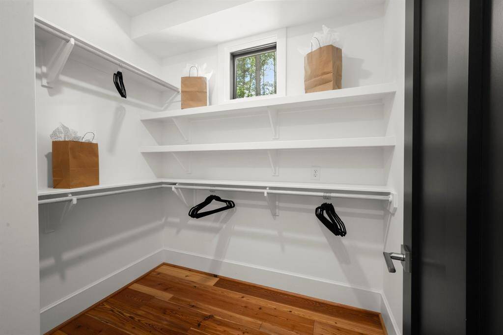 The reclaimed pine wood floors carry into the second primary closet.