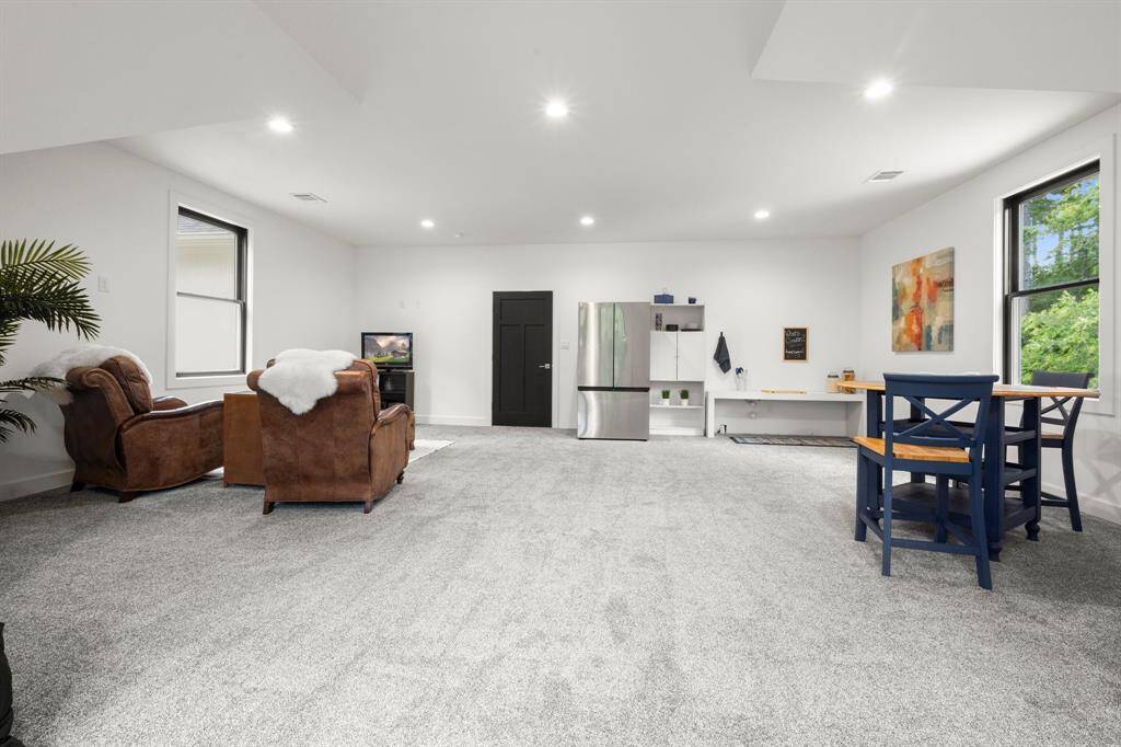 Upstairs gameroom/flex space is incredibly versatile and large enough to be used as a private living and kitchen areas for long-term guests.