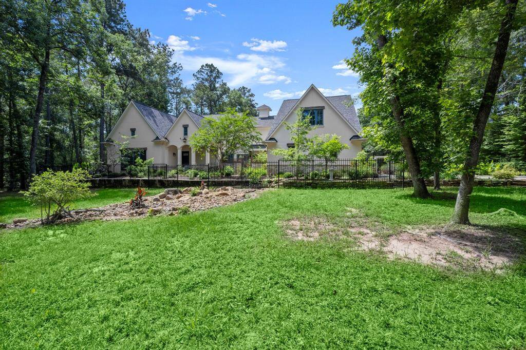 Mature trees surround the home's French-inspired stucco & stone exterior.