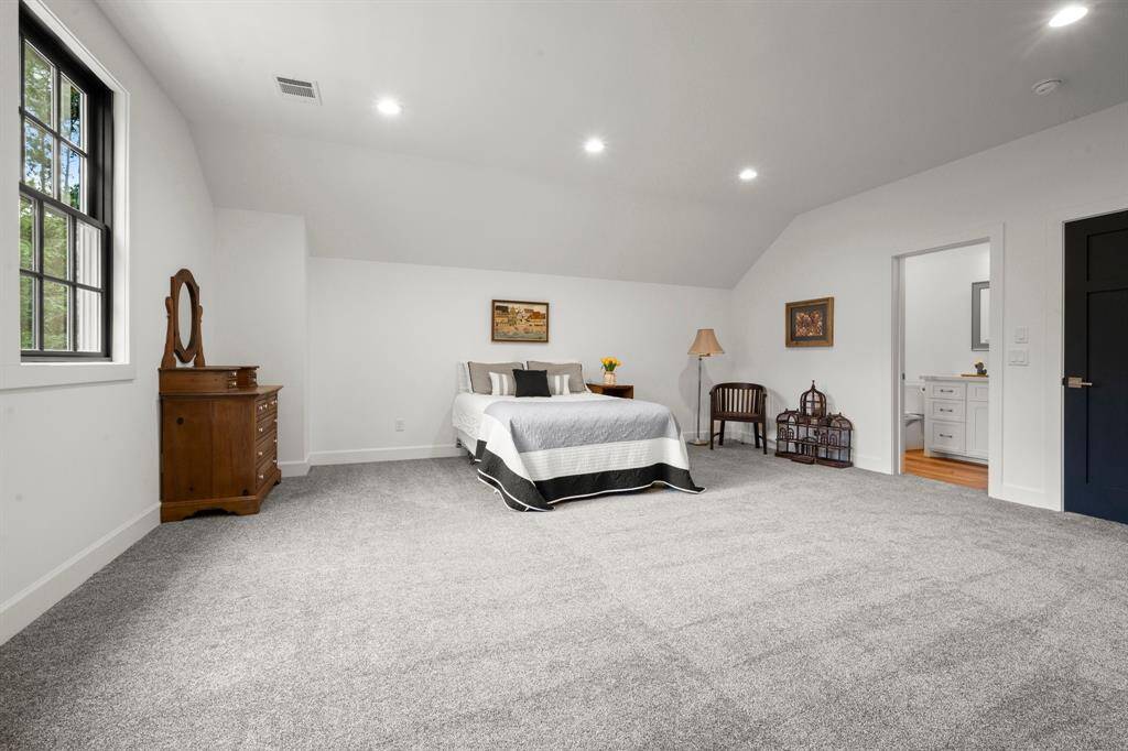 Upstiars guest suite with vaulted ceilings and attached full bathroom.