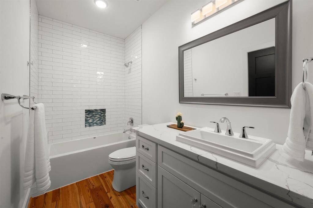 Quartz countertops, framed mirror, and reclaimed antique pine flooring.
