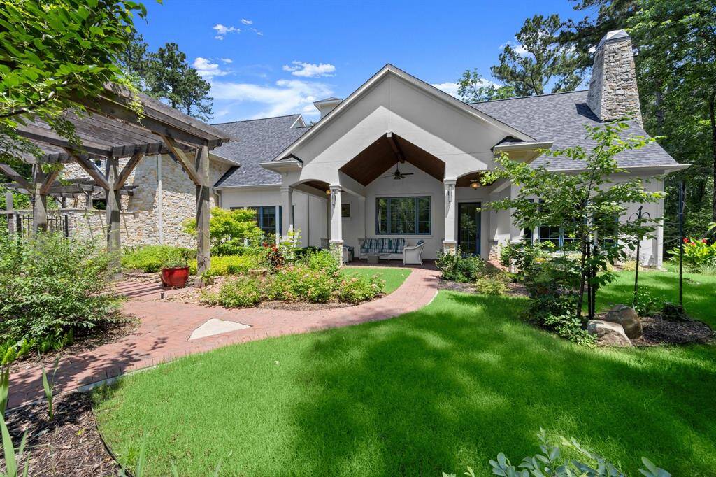 The backyard's lush gated landscape  and view of the spacious covered back patio area