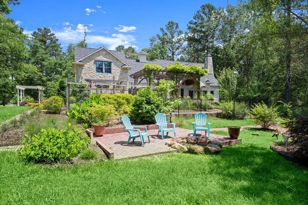 The built-in firepit area with cobblestone-lined patio offers even more to enjoy in the backyard landscape by the water.