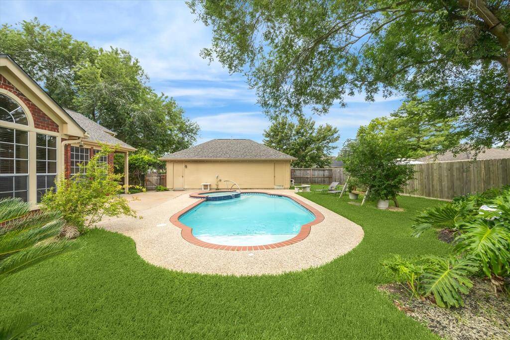View of the backyard with landscaping and the pool!