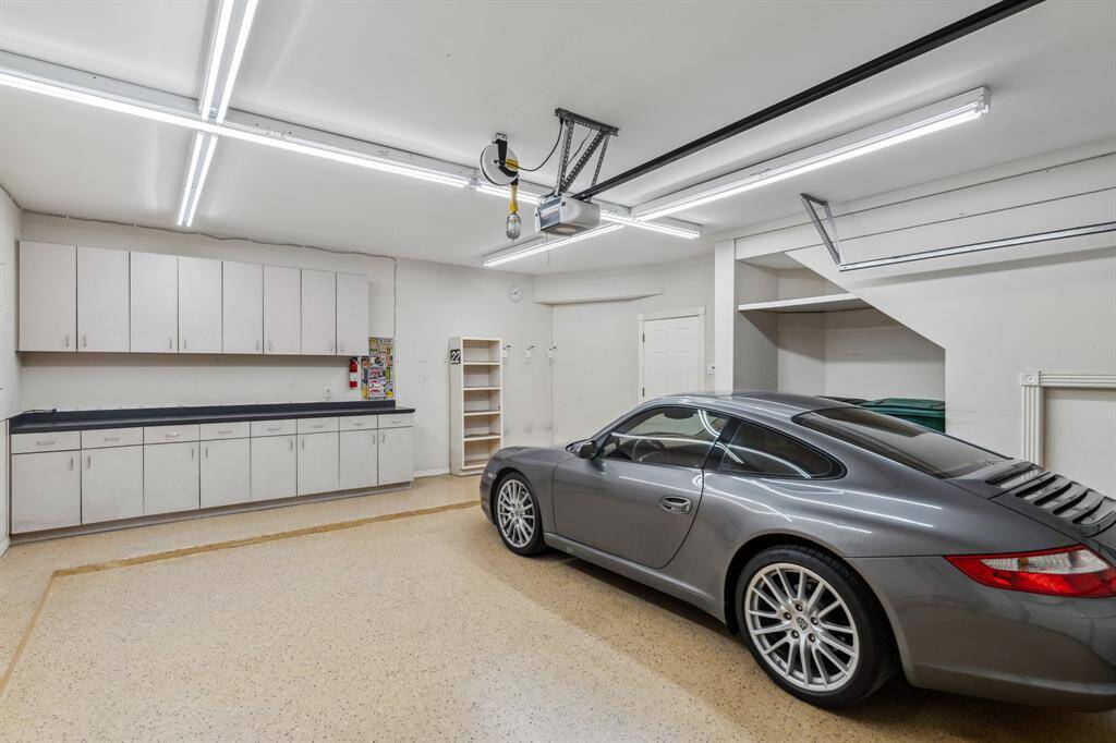 Oversized garage with built-in storage, workstation, and room for trash bins tucked away neatly.