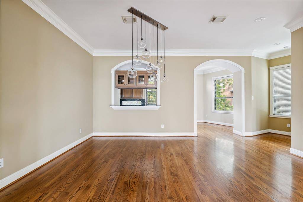 Bright, open dining area with elegant light fixture and hardwood flooring.