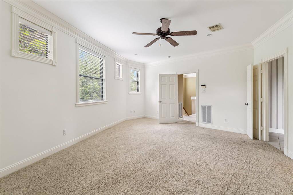 Alternate view of the primary suite highlighting wall space, natural light, and calm neutral tones.