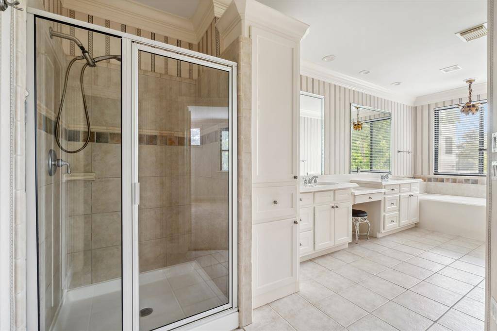 Another angle of primary bath showing clean finishes and natural light.