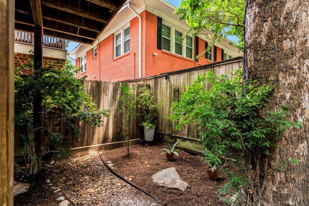 Backyard with tall fencing for privacy and open area for gatherings or relaxation.