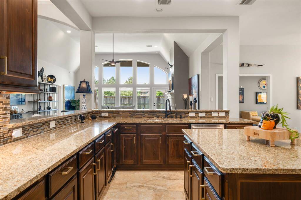 This alternate view of the beautiful kitchen showcases the beautiful rich cabinetry and granite countertops with plenty of outlets for all your gadgets.
