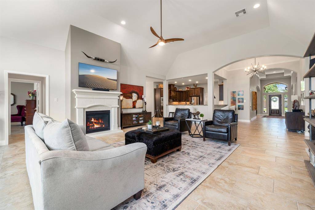 This light and bright spacious living room is the perfect layout for entertaining or just relaxing. Whether it's simply a night in or entertaining family and friends, this home has ample open space for everyone to enjoy! Featuring custom ceiling fan, large tile flooring, large windows with blinds, soaring high ceilings, recessed lighting with wonderful access to your gorgeous kitchen.