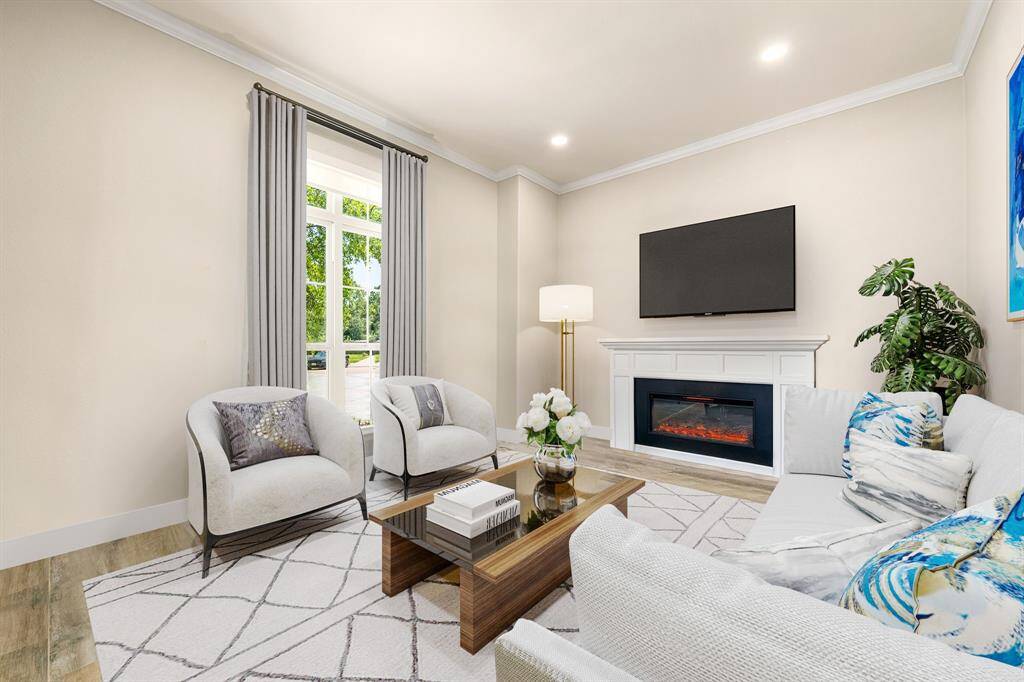 A bright and inviting formal living room nestled at the front of the home featuring neutral paint and fire place with mantel detailing, crown molding, recessed lighting and plenty of natural light to brighten the room.