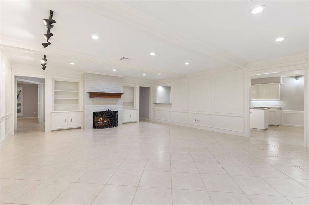 This oversized family room features custom built-ins and a gaslog fireplace.