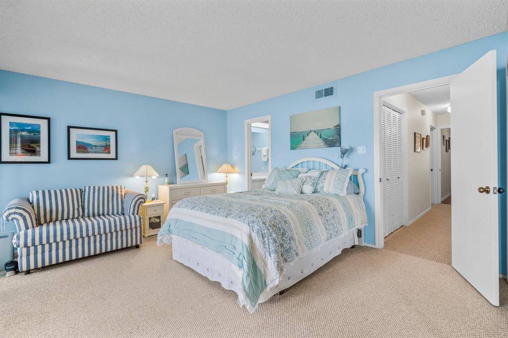 Primary Bedroom and view of hallway to additional storage