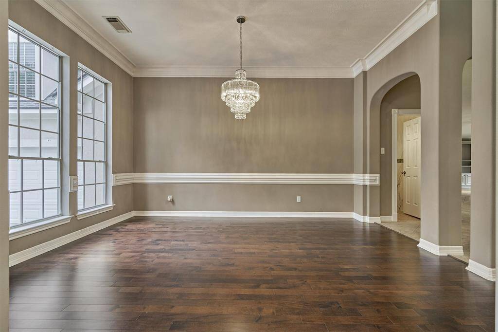 The dining room is complete with a brilliant chandelier and elegant arches.
